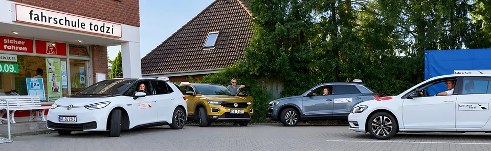 Fahrschulautos und Motorräder der Fahrschule Todzi vor der Fahrschule