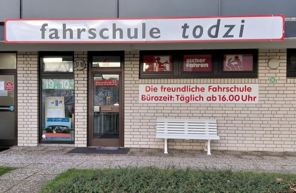 Eingang der Fahrschule Todzi in Garstedt, Berliner Allee 17–19, mit Schild und Sitzbank